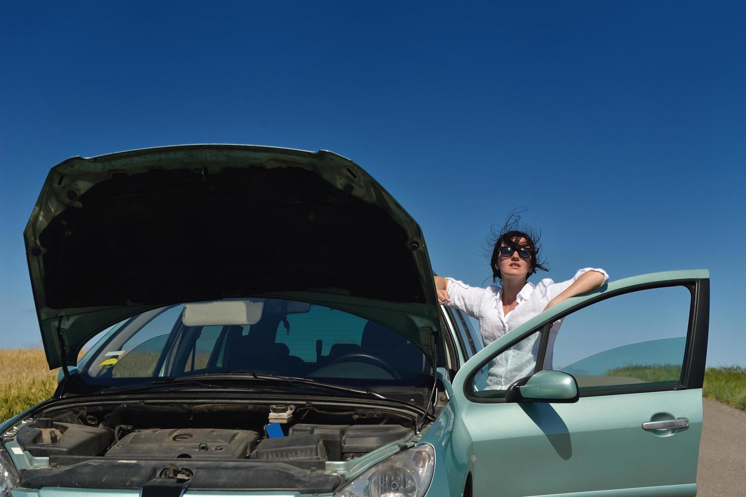 Frau mit kaputtem Auto foto