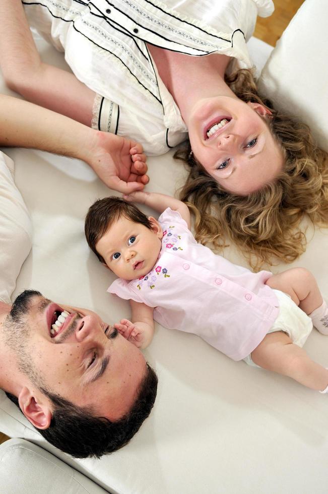 Innenporträt mit glücklicher junger Familie und süßem kleinen Babby foto