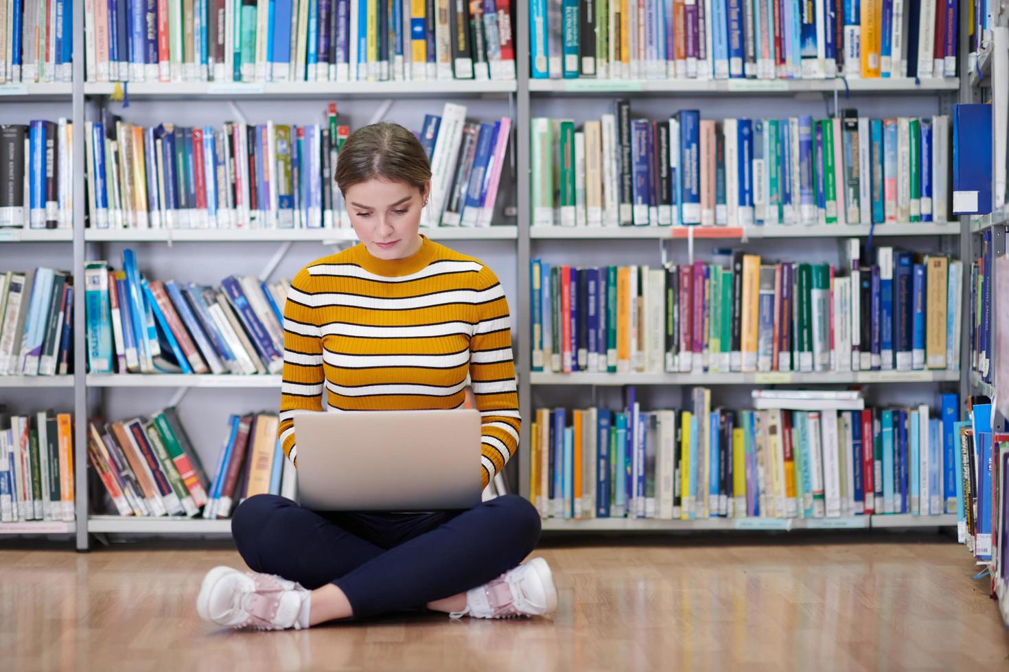 der Schüler benutzt ein Notizbuch und eine Schulbibliothek foto