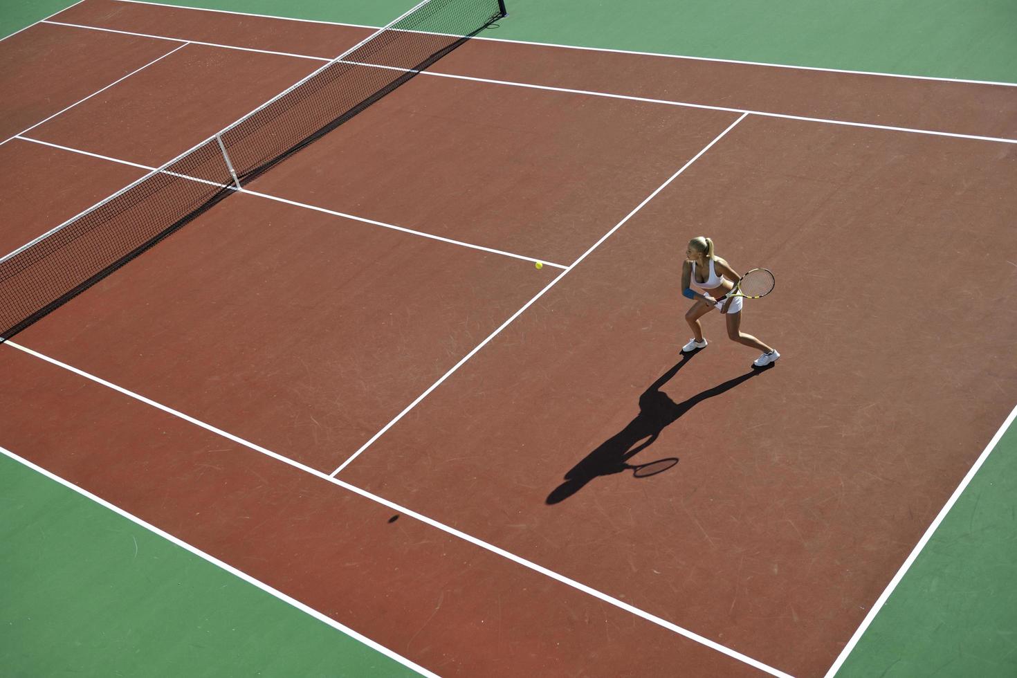 junge Frau spielt Tennis im Freien foto