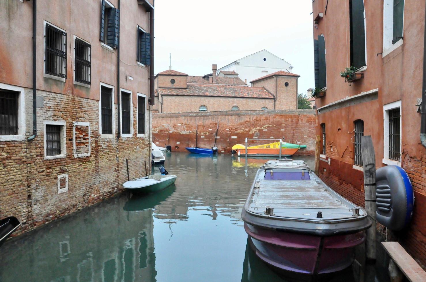 Klassischer Blick auf den Kanal von Venedig mit typischen Gebäuden, bunten Fenstern, Brücken und Booten foto