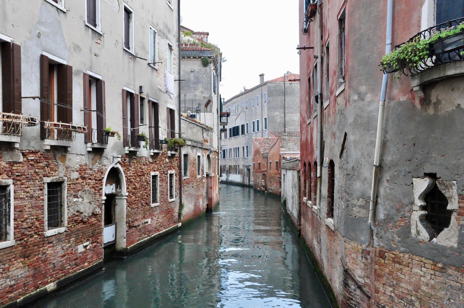 Klassischer Blick auf den Kanal von Venedig mit typischen Gebäuden, bunten Fenstern, Brücken und Booten foto