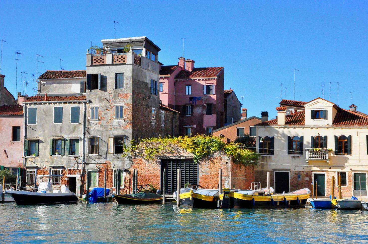 nicht touristischer teil von venedig mit leeren stillen bunten gebäuden, fenstern, straßen und booten foto