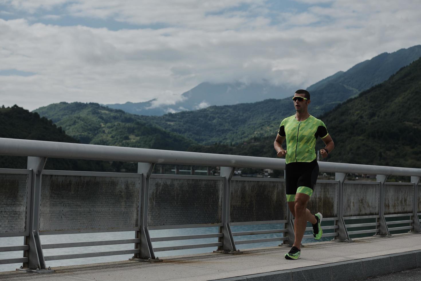 Triathlonsportler, der auf der Straße läuft foto