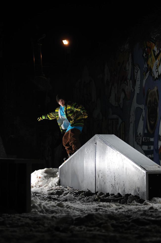 Freestyle-Snowboarder springen nachts in die Luft foto