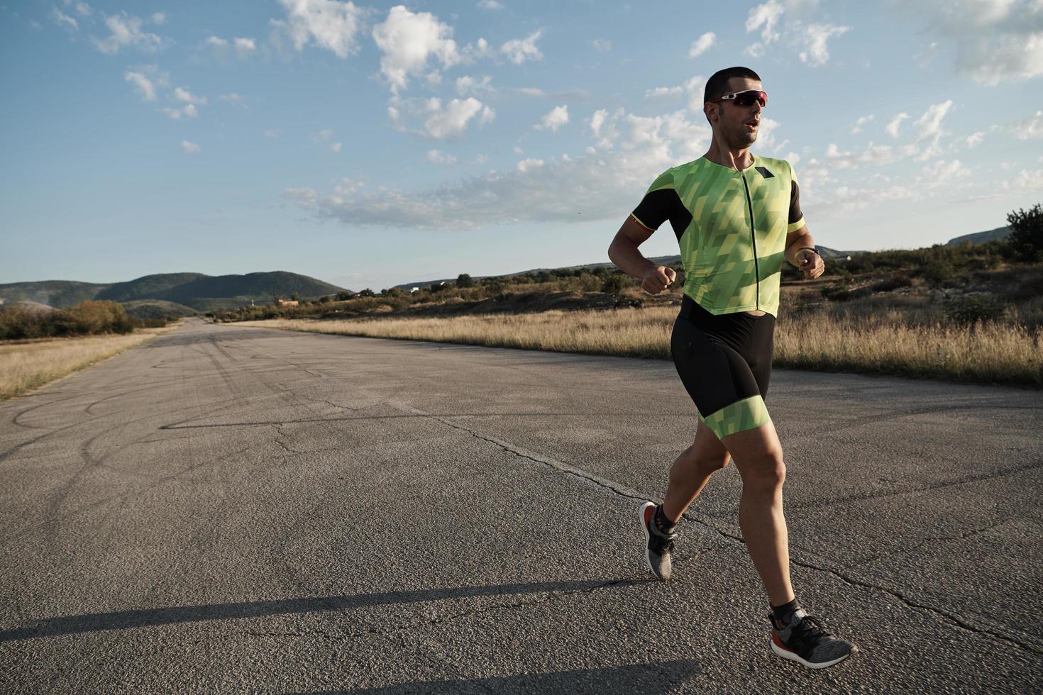 triathlonsportler, der beim morgendlichen training läuft foto