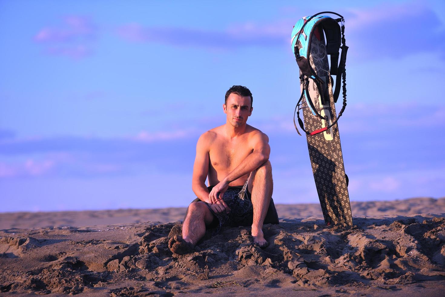 Porträt eines jungen Kitsurf-Mannes am Strand bei Sonnenuntergang foto