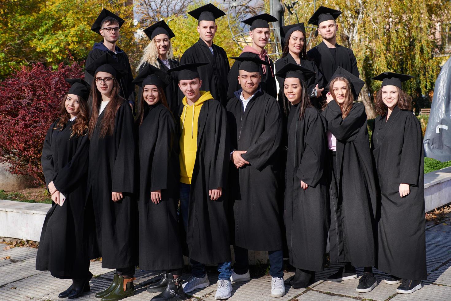 Gruppe verschiedener internationaler Absolventen, die feiern foto