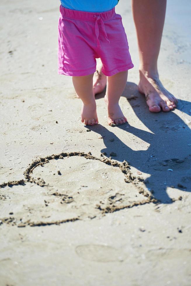 Mama und Baby am Strand haben Spaß foto