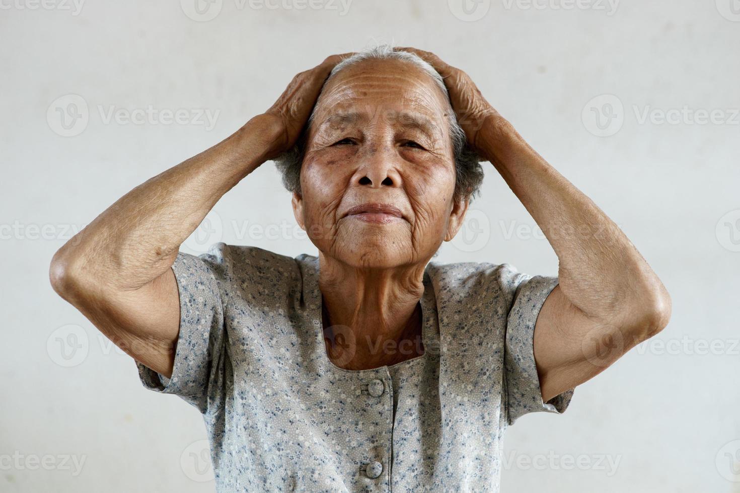 ältere asiatische frau hatte kopfschmerzen foto