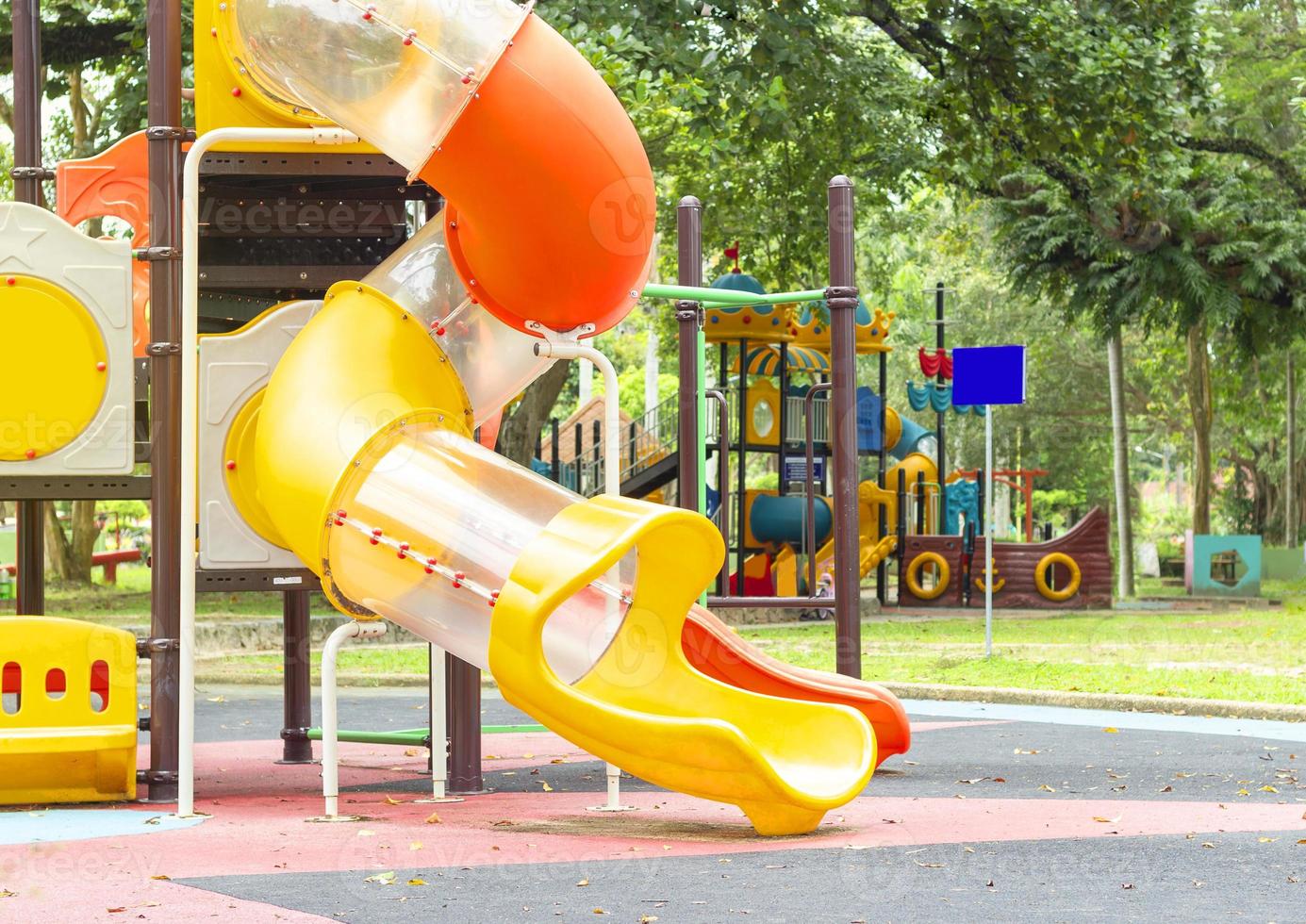 Schließen Sie den bunten Schieberegler im Freien und Spielgeräte auf dem Spielplatz im öffentlichen Park foto