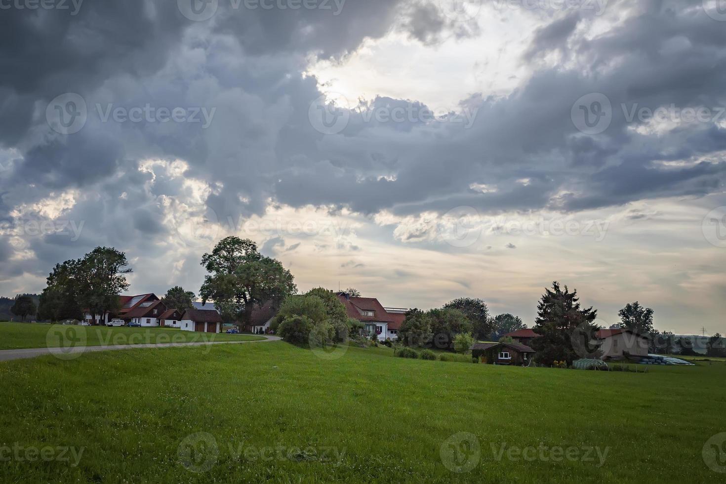 idyllische landschaft mit grüner wiese, straße und traditionellen deutschen bauernhäusern. foto