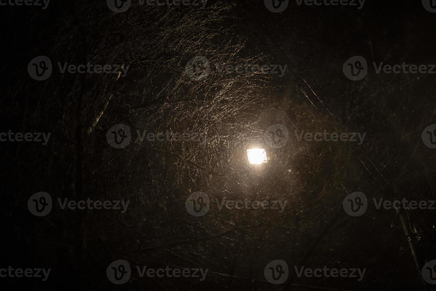 Schneesturm nachts in der Stadt. Licht im Dunkeln. Niederschlag und Schnee. foto