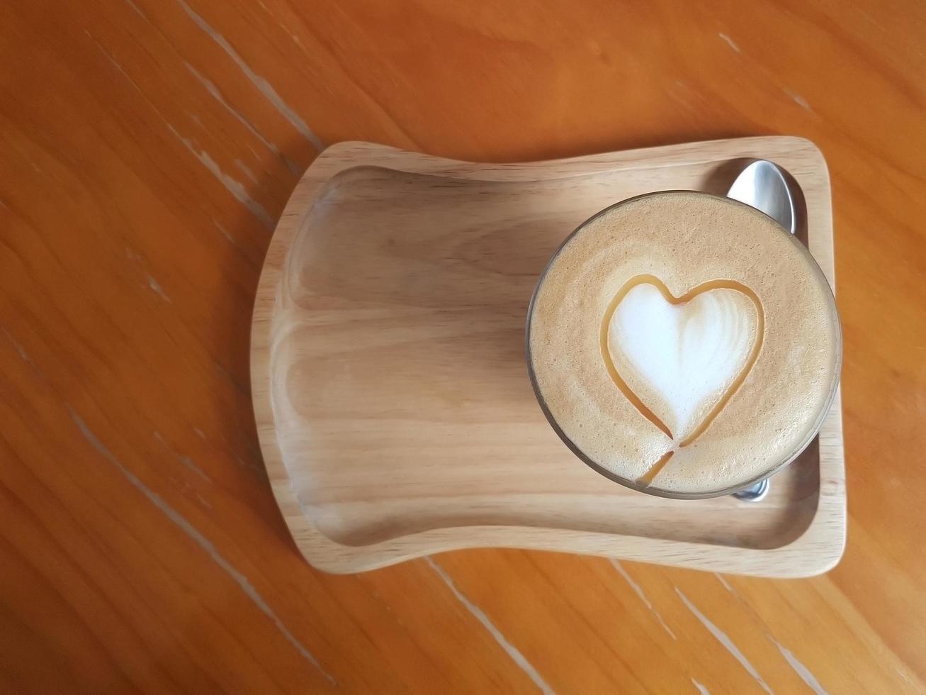 Draufsicht auf Kaffee mit herzförmiger Latte Art aus aufgeschäumter Milch und Karamellsoße. foto