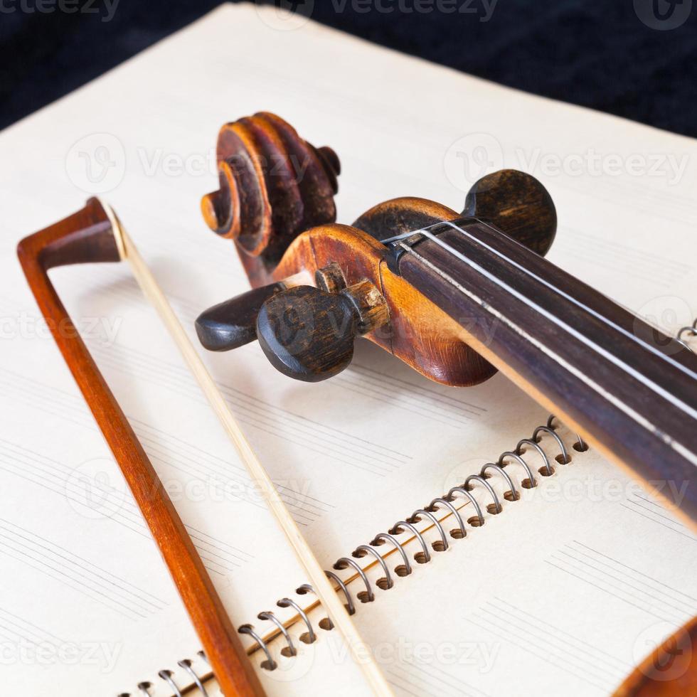 Geigenbogen und Scrollen auf Musikbuch foto