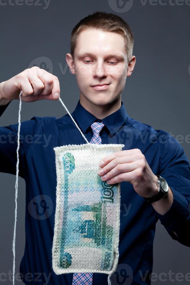 Geschäftsmann zerlegt den 1000-Rubel als Strickstoff foto