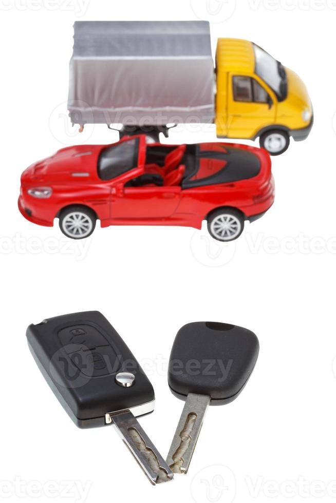 zwei Fahrzeugschlüssel und Modell-LKW und -Auto foto
