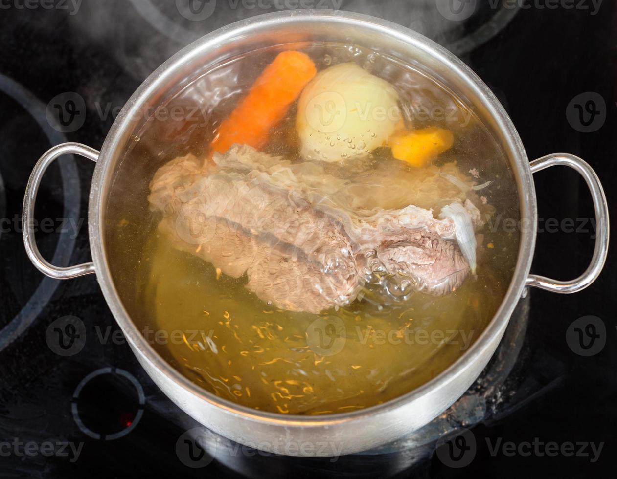 Rinderbrühe mit Gewürzgemüse aufkochen foto