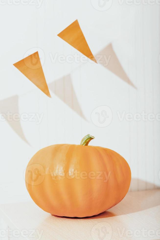 Kürbis und orangefarbene Fahnen Ammer. Wohnkultur für Halloween-Feier. Herbsternte, saisonale Dekoration. vertikale Größe. foto