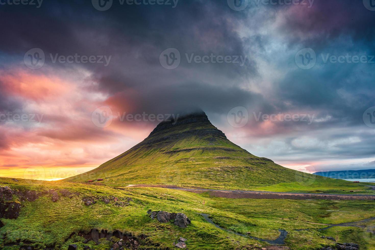 landschaft des sonnenuntergangs über dem berg kirkjufell mit bunter haufenwolke im sommer auf island foto