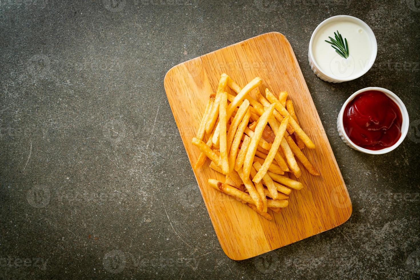 Pommes Frites mit Sauerrahm und Ketchup foto