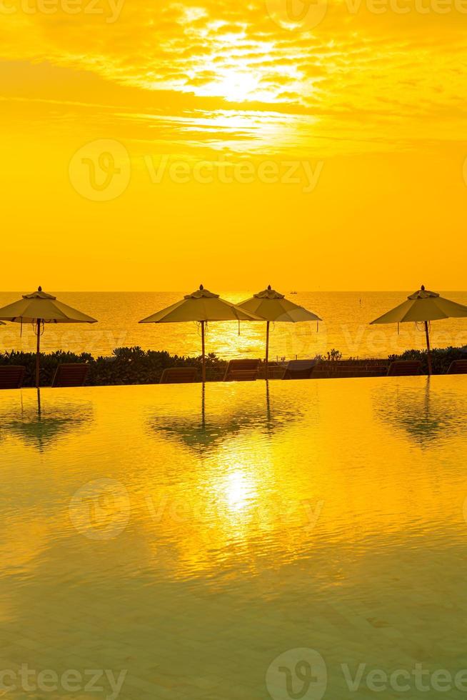 Sonnenschirm mit Bettpool um den Pool mit Ozean-Meer-Hintergrund foto