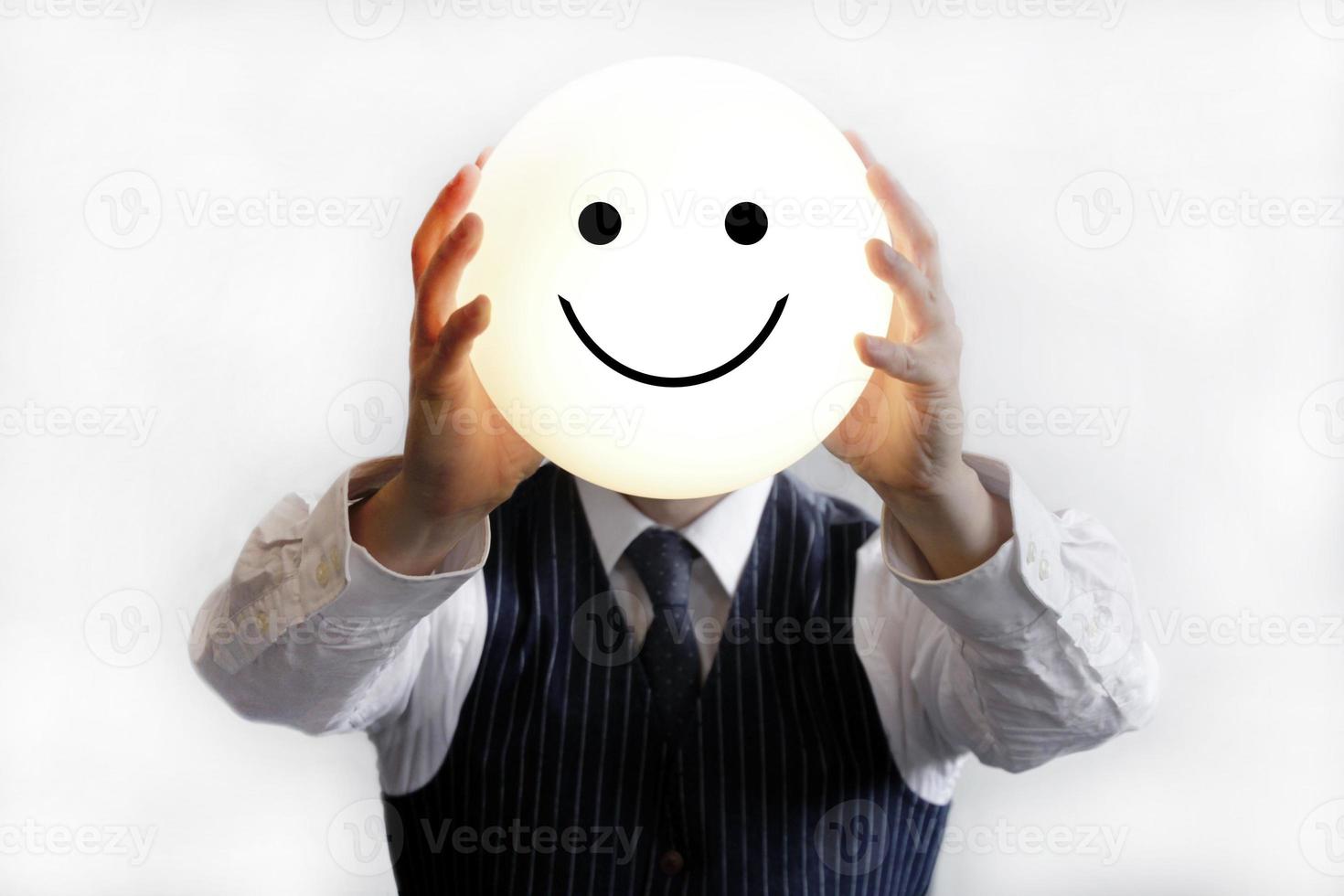 Geschäftsmann hält einen leuchtenden Smiley hoch foto
