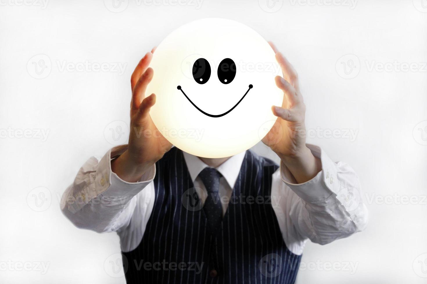 Geschäftsmann hält einen leuchtenden Smiley hoch foto