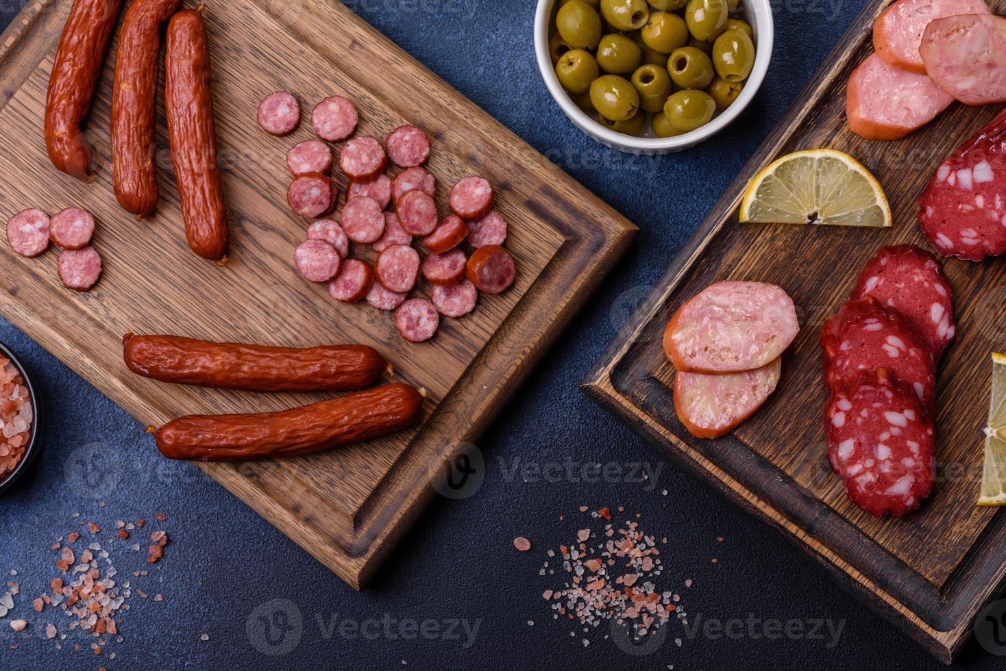 Köstliche frisch geräucherte Würste, die mit Scheiben auf einem Holzschneidebrett geschnitten werden foto