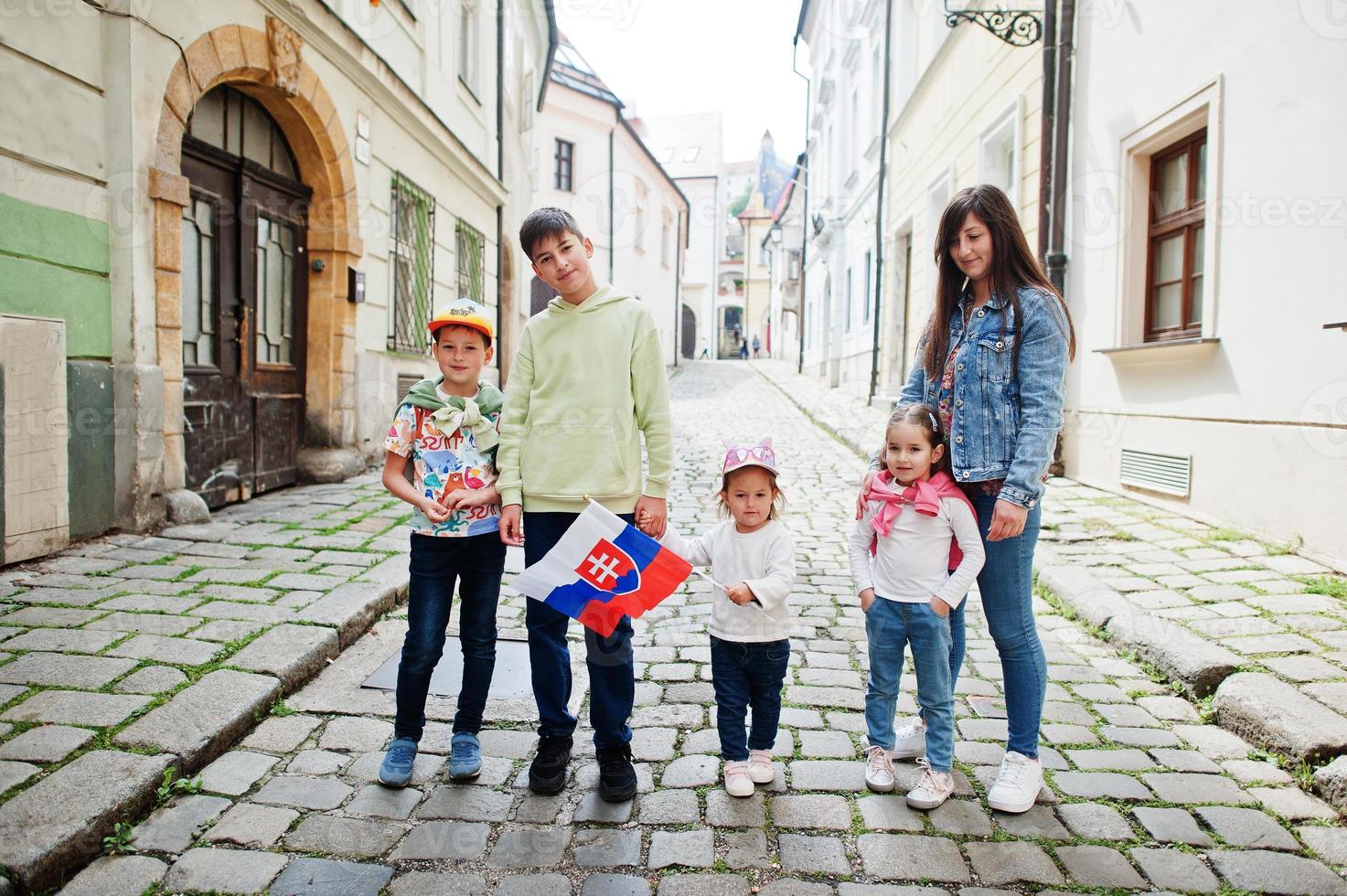 mutter mit kindern auf der straße von bratislava halten slowakische flagge. foto