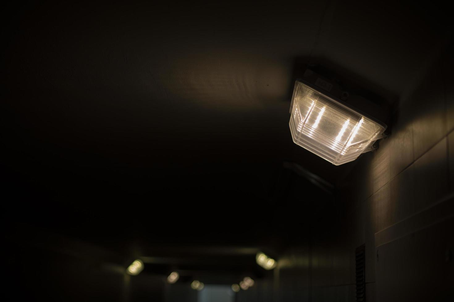 Lampe im Tunnel. Licht im Flur. Dunkelheit in der Unterführung. foto