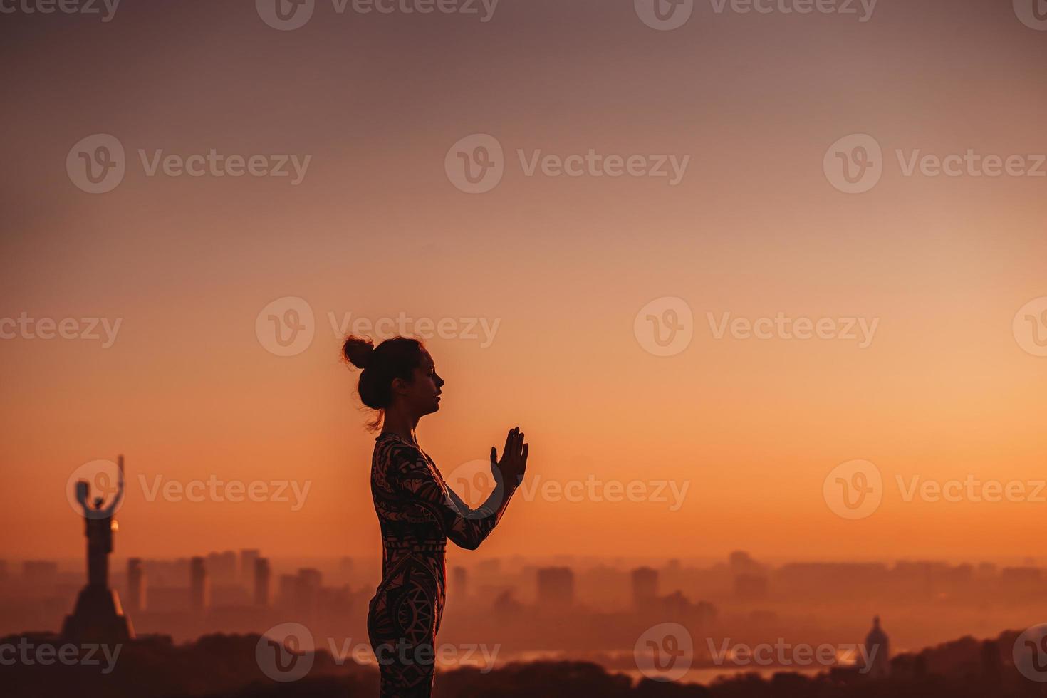 Frau beim Yoga auf dem Dach eines Wolkenkratzers in der Großstadt. foto