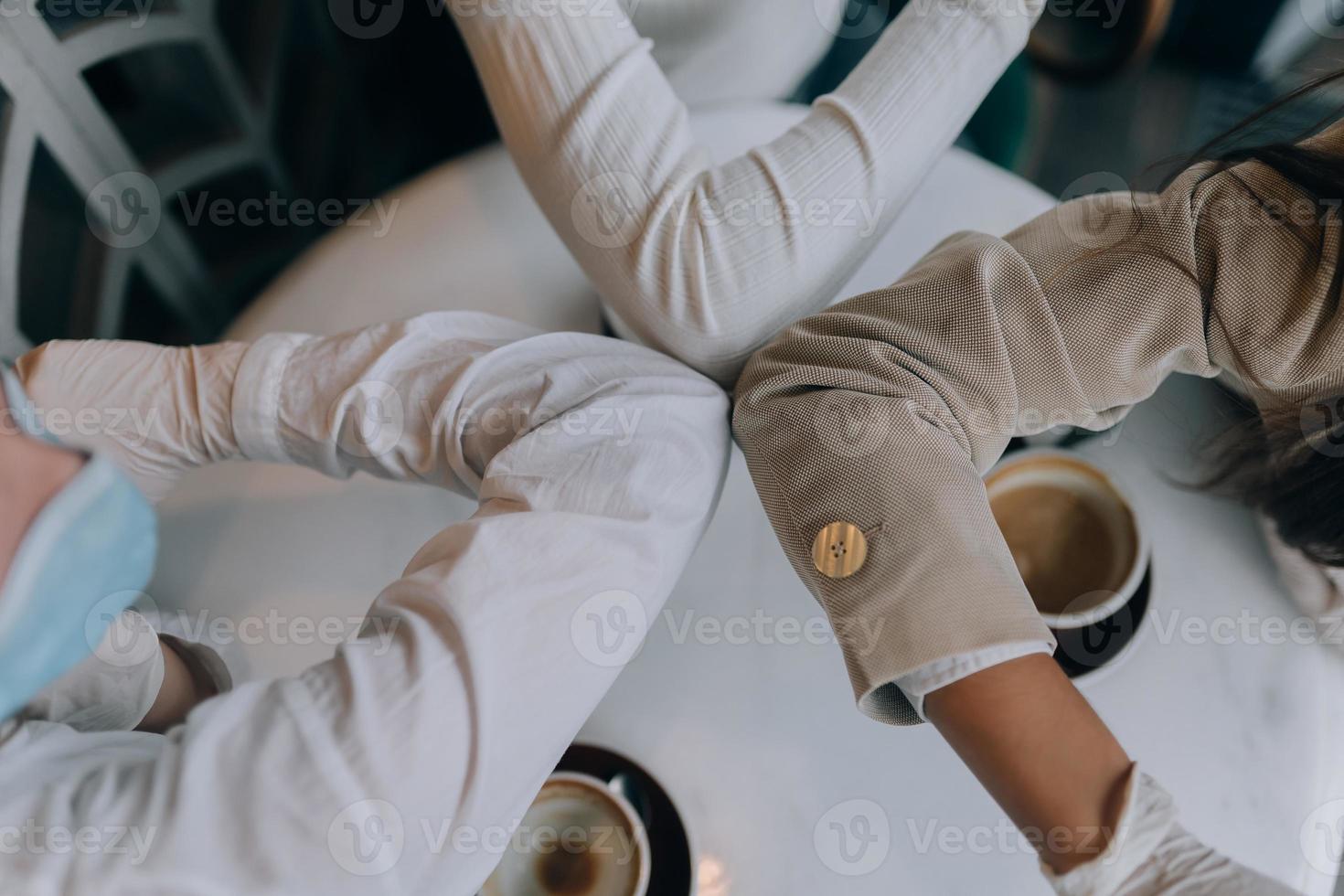 mitarbeiter in schutzmasken geben high five mit ellbogen. foto