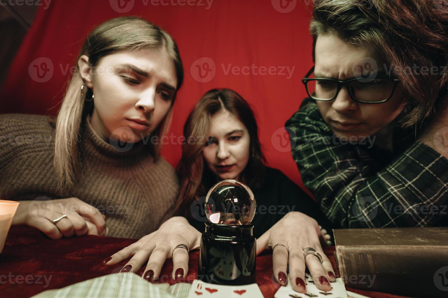 Gruppe von Menschen und Frau Wahrsagerin mit Kristallkugel foto