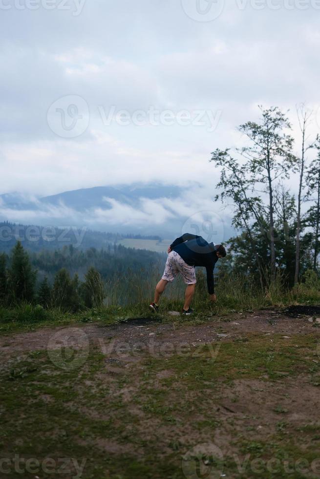 Kerl oben auf einem Hügel mit Blick auf die Natur foto