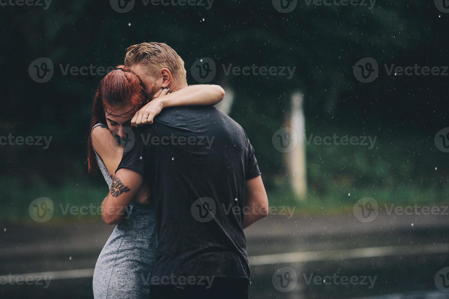 Schönes Paar, das sich im Regen umarmt foto