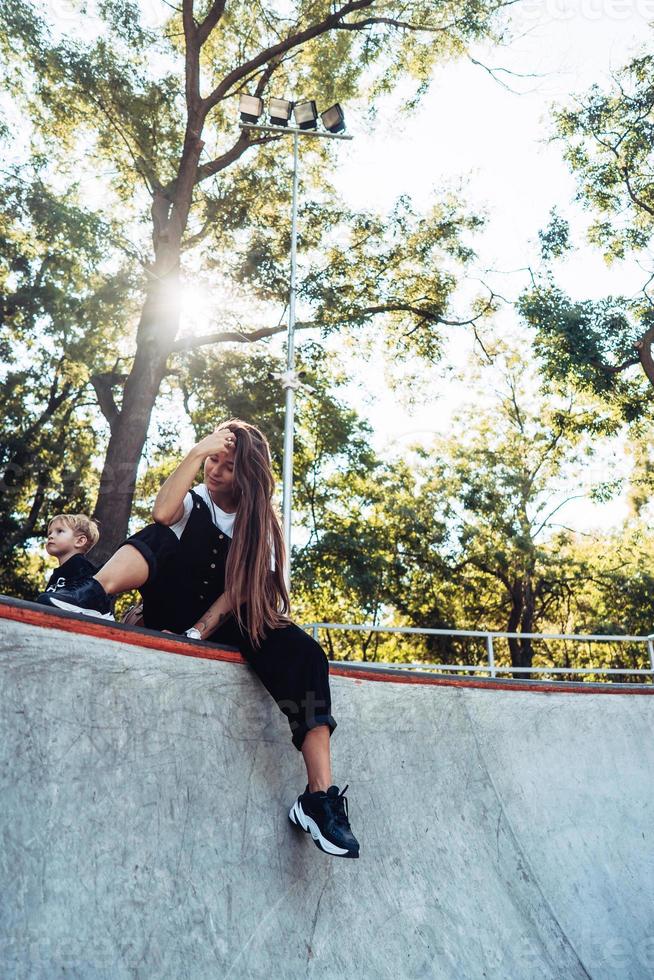 Schönes junges Hipster-Mädchen, das am Rand einer Rampe sitzt foto