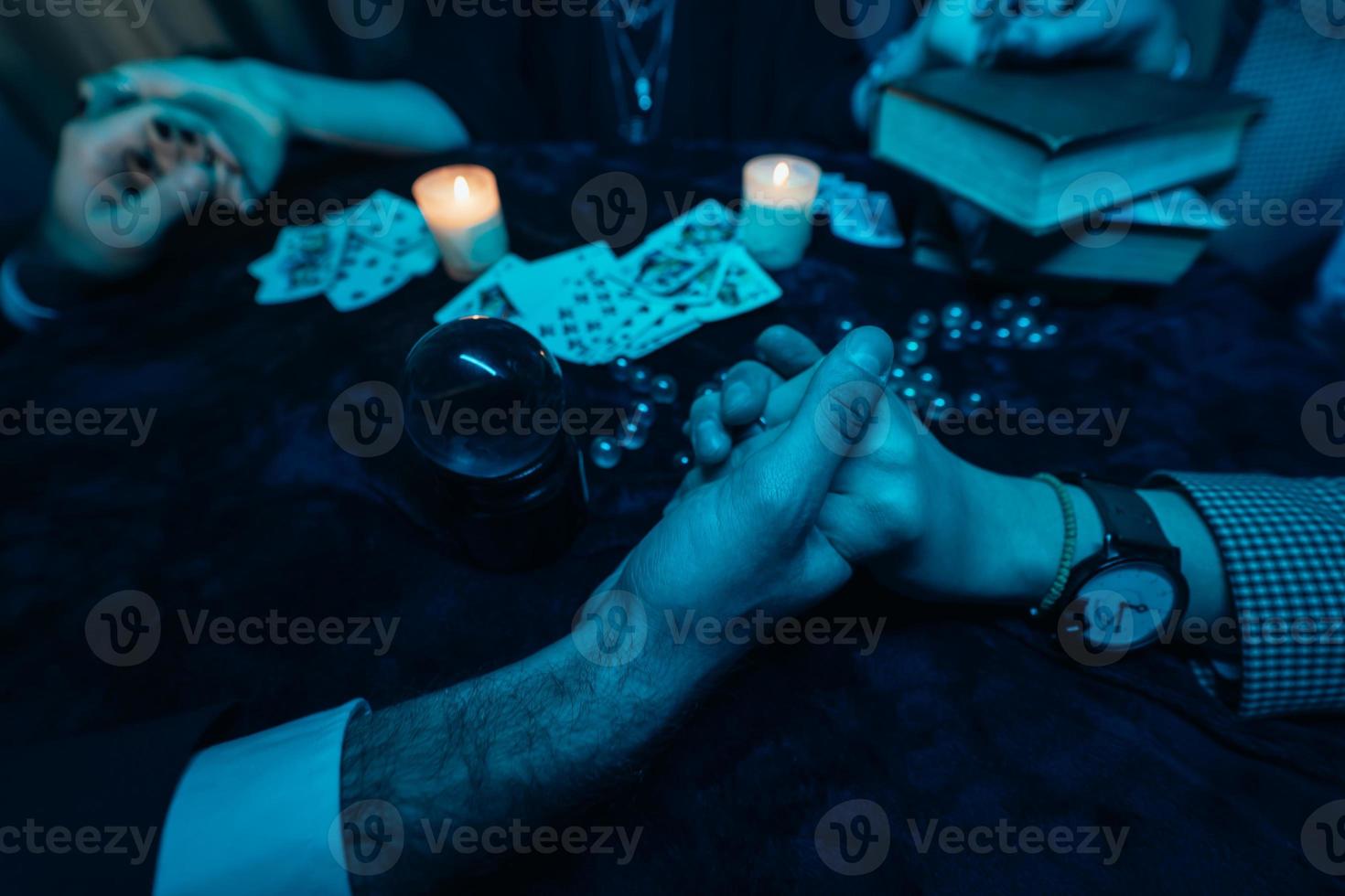 die leute halten sich nachts am tisch mit kerzen an den händen foto