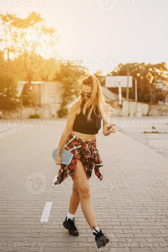 junges Mädchen mit einem Skateboard auf einem Parkplatz. foto