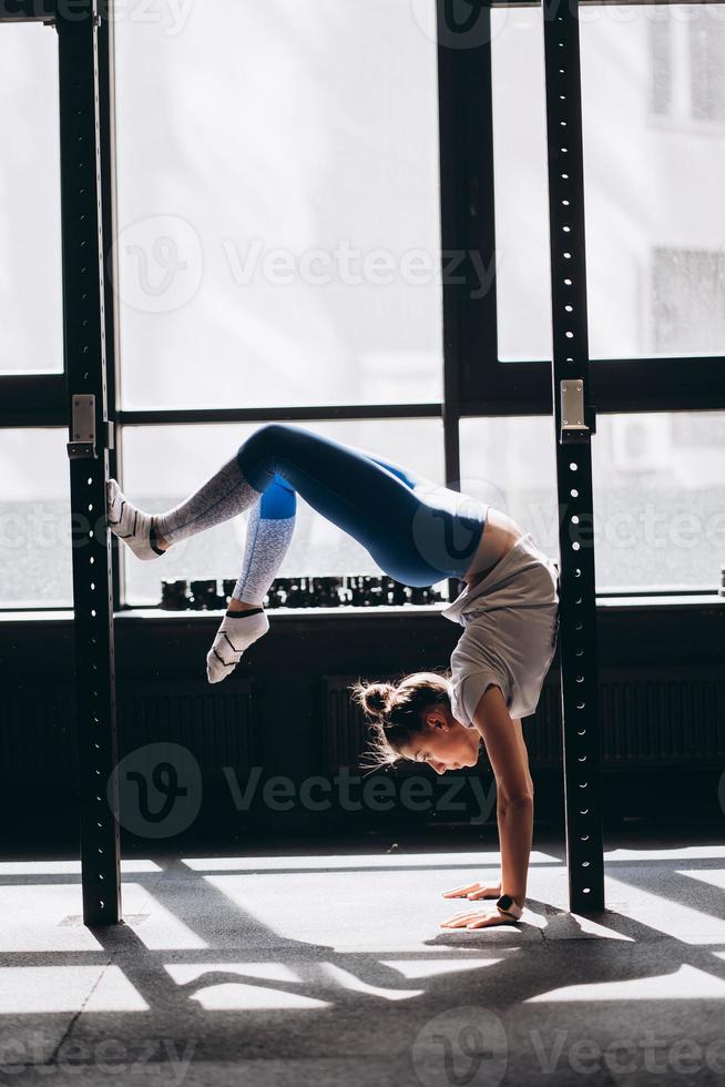 Porträt einer attraktiven jungen Frau, die Yoga- oder Pilates-Übungen macht foto