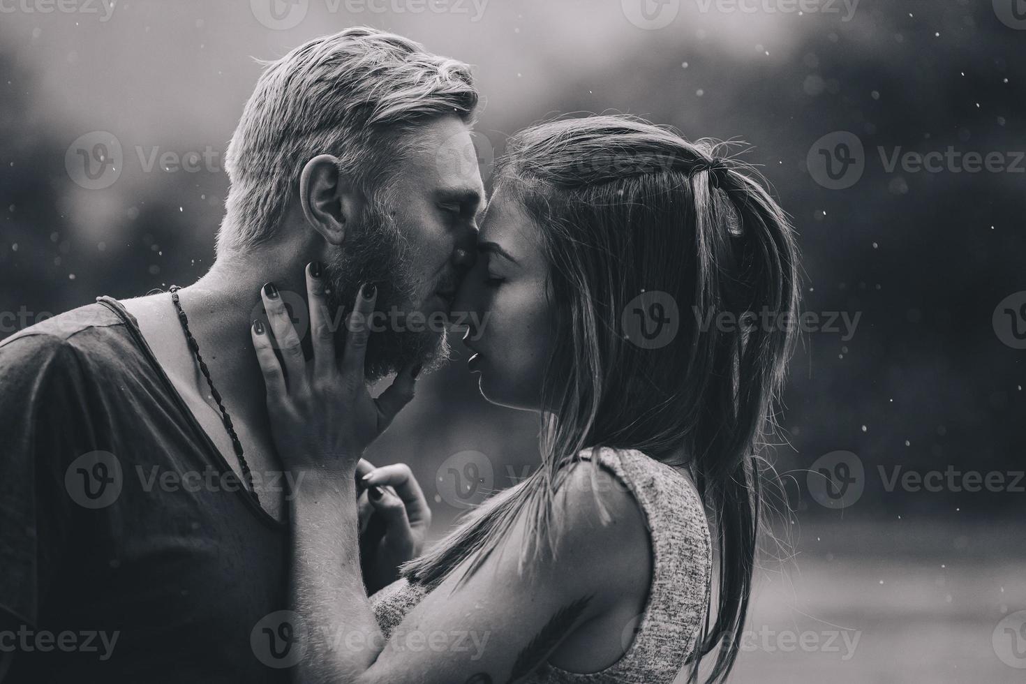 Schönes Paar, das sich im Regen küsst foto