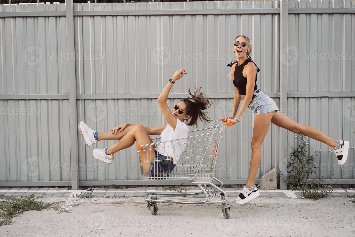 Freunde fahren auf Karren, in der Nähe des Supermarkts foto