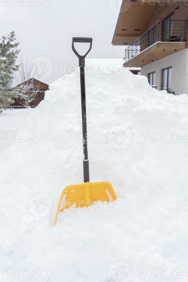 eine gelbe Schaufel, die im Schnee steht foto