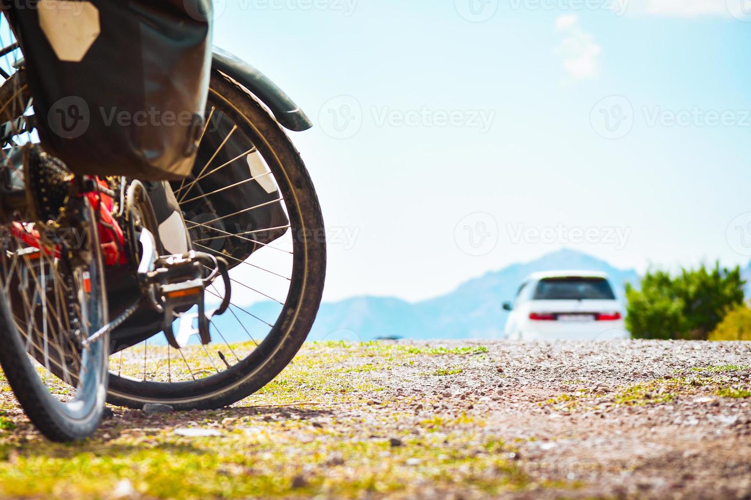 voll beladener Fahrradständer neben der Straße mit dem Auto in der Natur vorbeifahren. sicherheit auf straßen- und fahrradtourenkonzept im freien foto