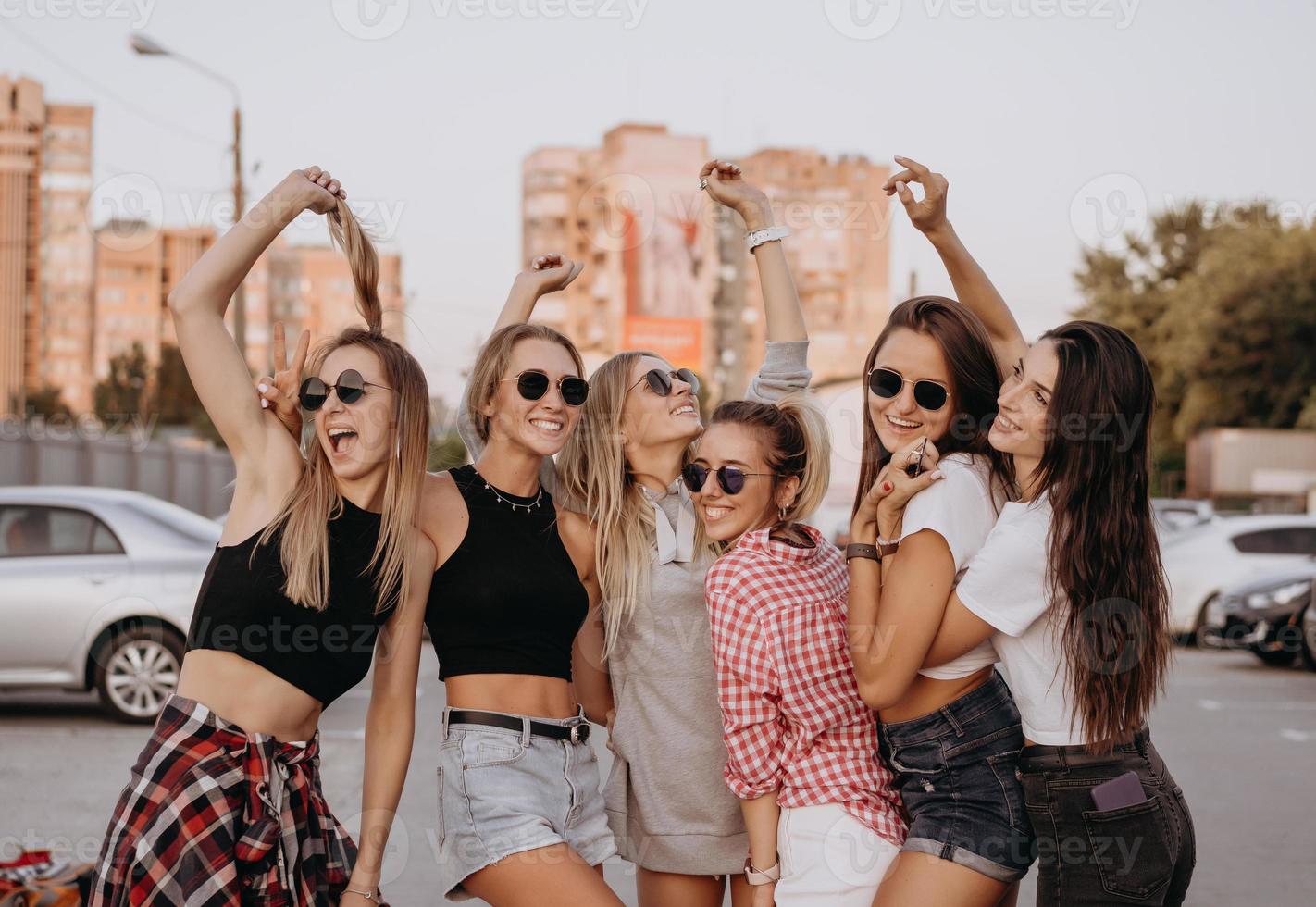 Sechs junge Frauen vergnügen sich auf dem Parkplatz. foto