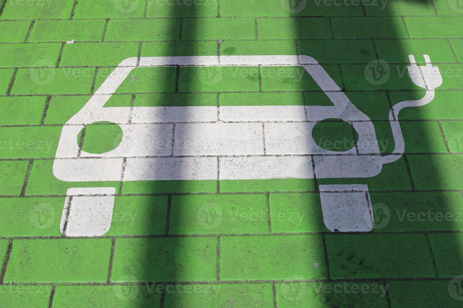 Schild einer Ladestation für Elektroautos auf einem blauen Parkplatz gemalt foto
