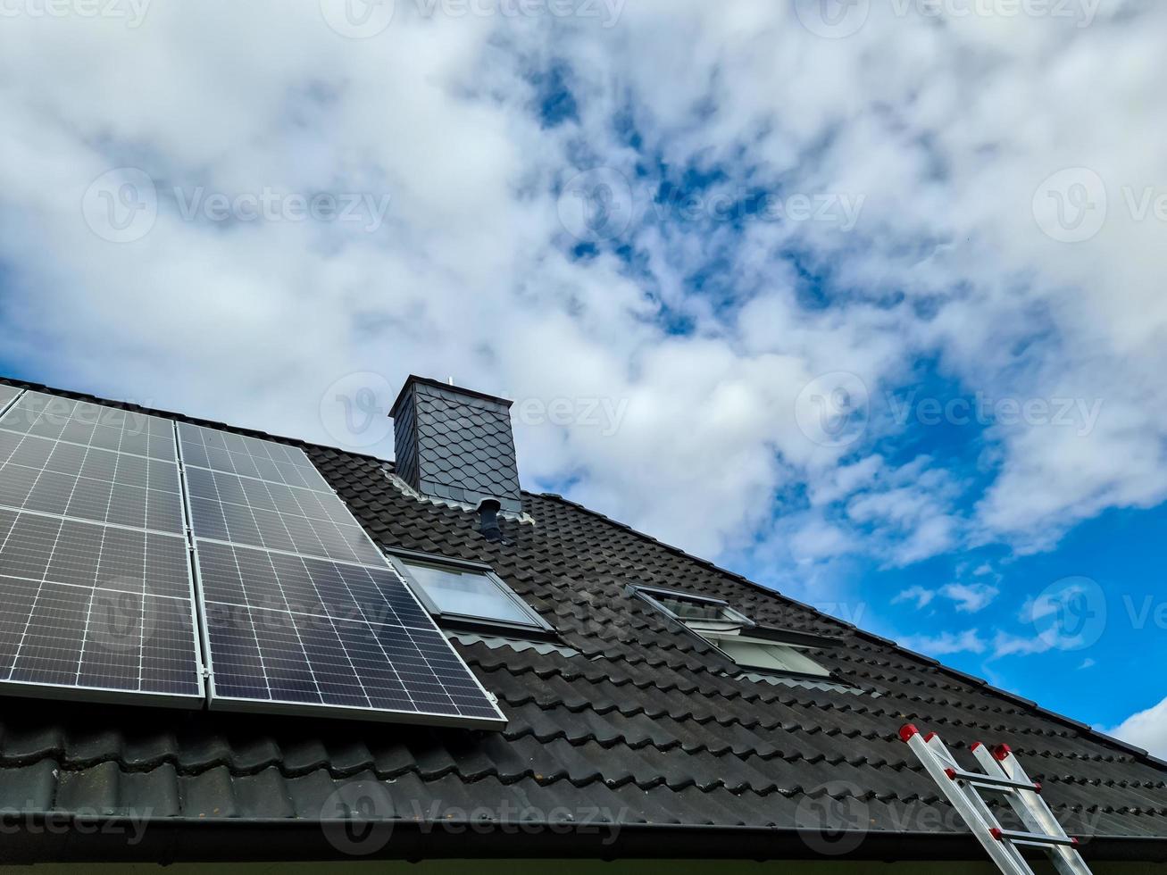 Sonnenkollektoren produzieren saubere Energie auf dem Dach eines Wohnhauses foto