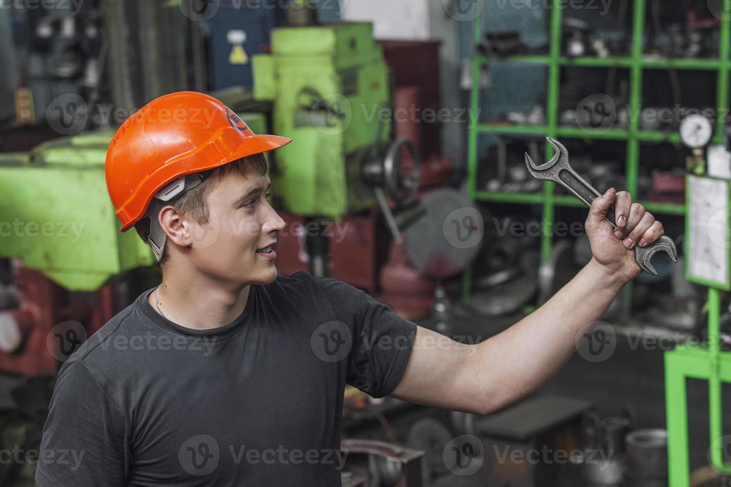 Der junge Mann arbeitet in der alten Fabrik an der Installation foto