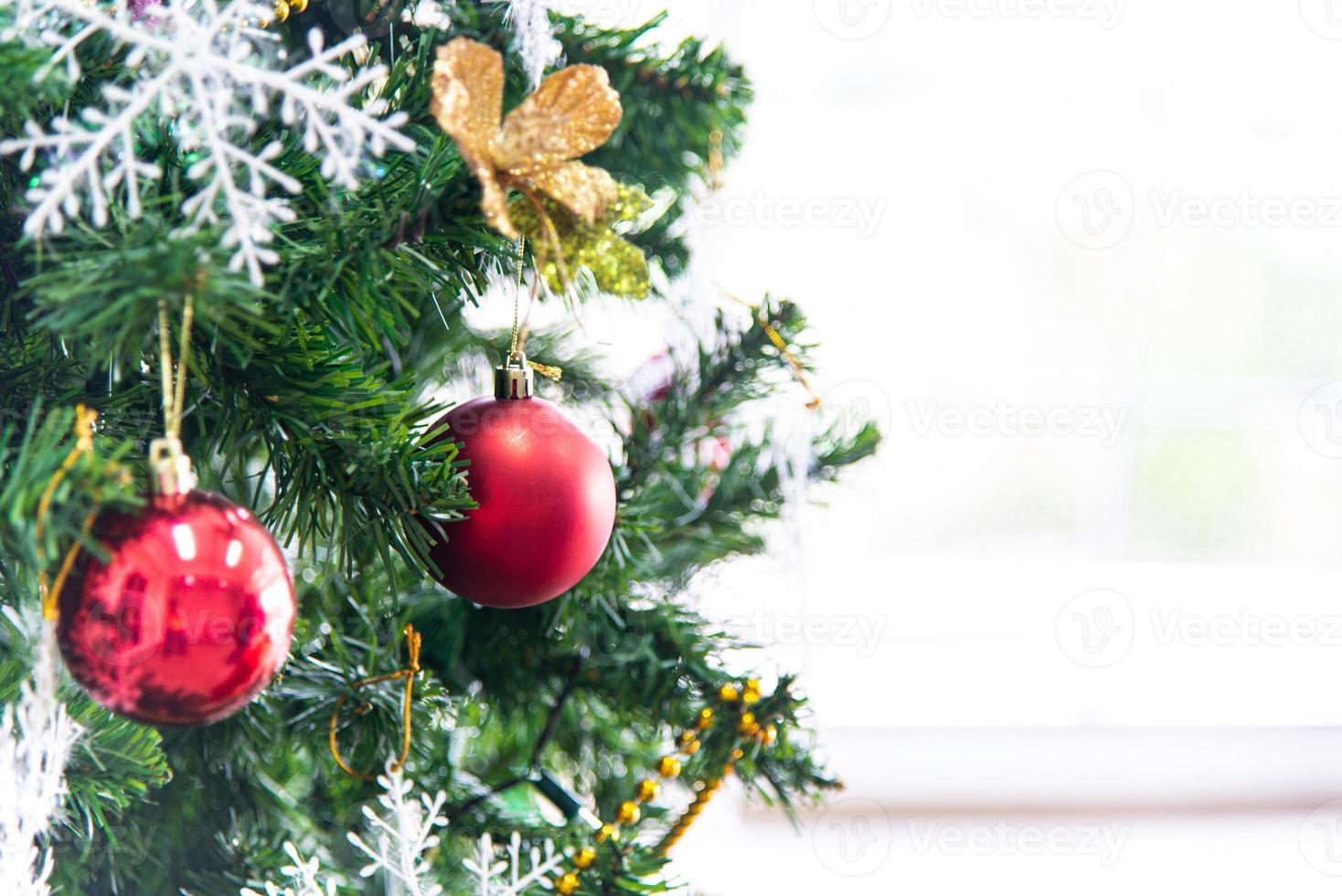 weihnachts- und neujahrsferienkonzept. Closeup Christbaumschmuck mit Bändern, Kugeln und Ornamenten über weiße Mauer und Bokeh foto