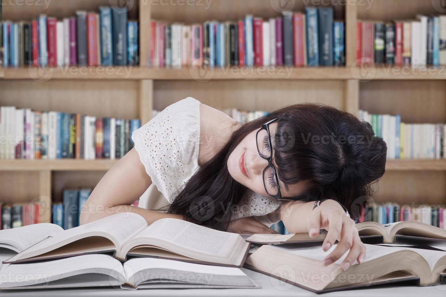 Student schläft und träumt in der Bibliothek foto